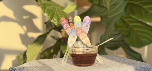 SANA VitaHoney honey spoon stirred into smoothie bowl as creative healthy food use