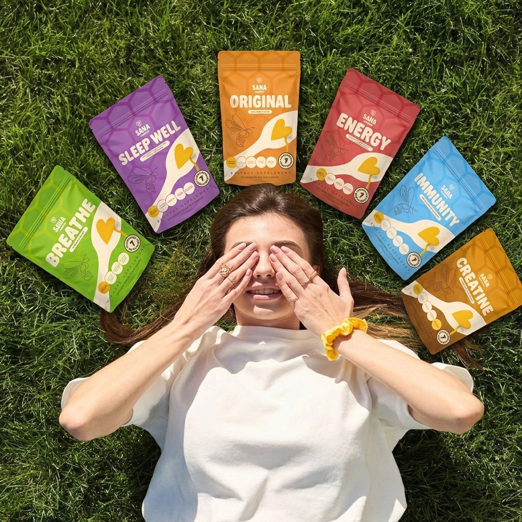 Woman lying on grass with various Sana VitaHoney Spoon Collection packages around her